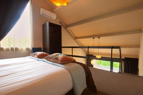 um quarto com uma cama grande e uma janela grande em Bosrijk Ruighenrode em Lochem