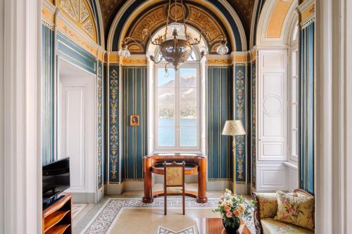 ein Wohnzimmer mit einem Stuhl und einem Fenster in der Unterkunft Grand Hotel Villa Serbelloni - A Legendary Hotel in Bellagio