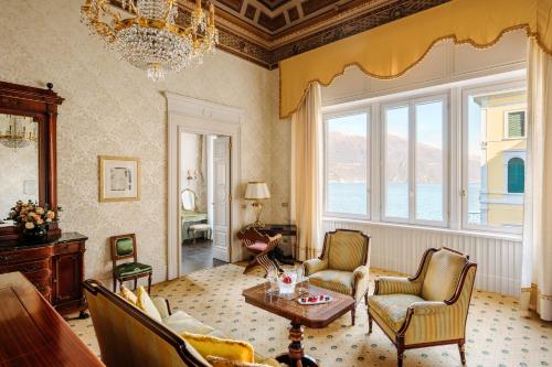 a living room with a table and chairs and a large window at Grand Hotel Villa Serbelloni - A Legendary Hotel in Bellagio