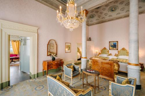 una camera con un grande letto e un lampadario a braccio di Grand Hotel Villa Serbelloni - 150 Years of Grandeur a Bellagio