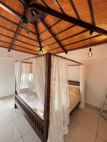 1 dormitorio con 2 camas con mosquiteras en Hut in the sky, en Bangalore