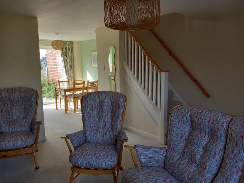 a living room with two chairs and a staircase at Seair in Rustington