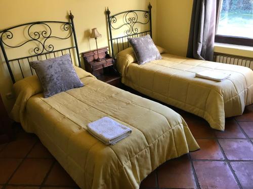 two beds sitting next to each other in a room at Casa Rural Los Robles in Acebo