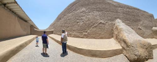 a group of three people standing next to a large rock at Ambigua Hospedaje in Trujillo