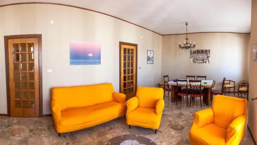 een woonkamer met 2 gele stoelen en een tafel bij B&b Lecce House in Lecce