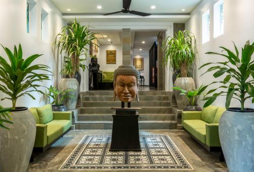 a lobby with a statue of a head on a table at People by The Community in Siem Reap