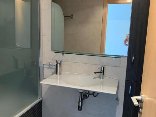 y baño con lavabo blanco y espejo. en Apartamento con piscina Cerca de la playa, en Sant Antoni de Calonge