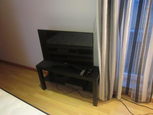 a flat screen tv sitting on a table next to a window at Casinha da Pedra in Tomar