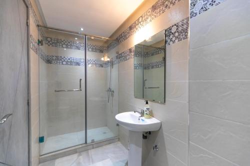 a bathroom with a shower and a sink and a glass shower stall at Luxury Apartment Fez in Fès