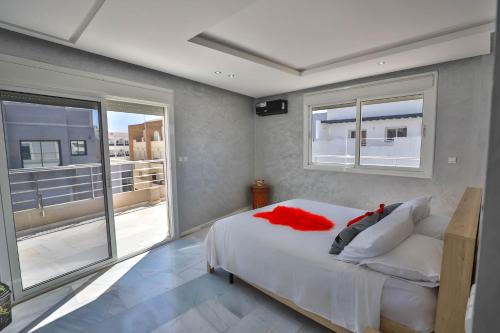 a bedroom with a large white bed and a balcony at Luxury Apartment Fez in Fès