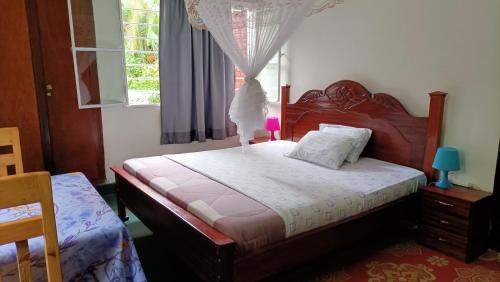 a bedroom with a bed and a window at COLIBRI TAVERNE Gisenyi in Gisenyi