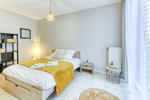 une chambre avec un lit avec une couverture jaune dessus dans l'établissement 5min Alpexpo 4 personnes garage privé terrasse, à Grenoble