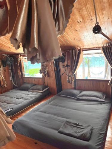 two beds in the back of a train room at Mộc Homestay Đảo Phú Quý in Cu Lao Thu