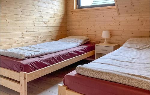 sypialnia z 2 łóżkami w drewnianym domku w obiekcie Cozy Home In Jantar With Wi-fi w mieście Jantar