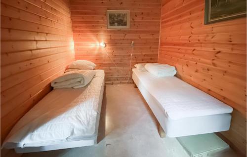 een kamer met 2 bedden in een houten hut bij Stuga 6 in Nybro