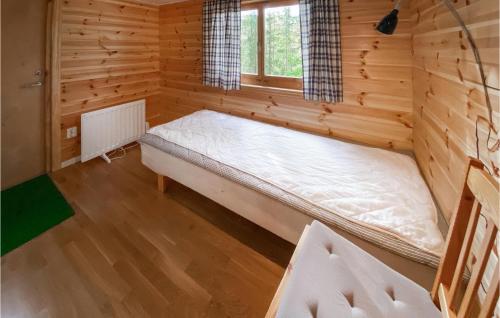 een kamer met een bed in een blokhut bij Stuga 2 in Nybro