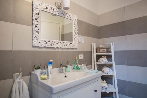 La salle de bains est pourvue d'un lavabo et d'un miroir. dans l'établissement La Tenenza B&B, à Città della Pieve