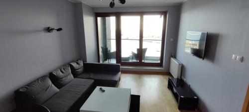 a living room with a couch and a table at Sea Towers Apartment in Gdynia