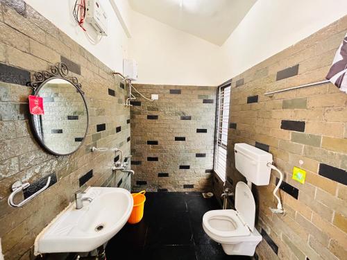 ein Badezimmer mit einem Waschbecken, einem WC und einem Spiegel in der Unterkunft NzoStay Casa Cobble Luxury Villa Alibaug in Alibag
