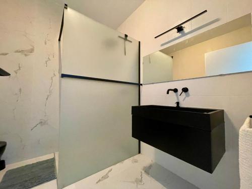 a bathroom with a sink and a mirror at Klimatizovaný Apartmánový dom s vírivkou, 10A in Senec