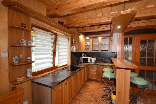 a kitchen with a counter and stools in a cabin at Chata Erika in Pusté Pole