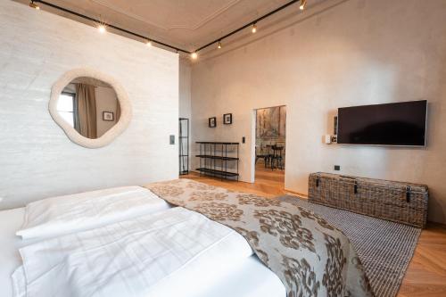 a bedroom with a bed and a tv on a wall at H5 Grauer Bär Studios & More in Innsbruck