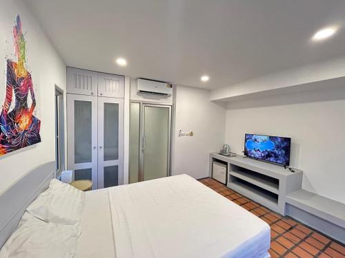 - une chambre blanche avec un lit et une télévision dans l'établissement Thiptara Resort, à Nathon Bay