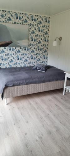 a bedroom with a bed with a lamp and a wall at Rosendal Apartments Motellet in Rosendal