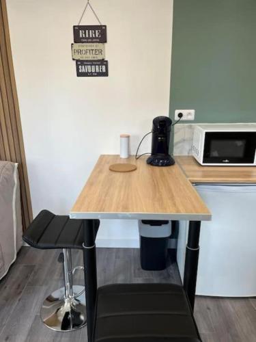 Cette chambre comprend une table en bois et un four micro-ondes. dans l'établissement Petite maisonnette proche de Giverny, à Bonnières-sur-Seine