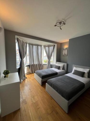 a bedroom with two beds and a window at Stunning House 15 min from Wembley arena in London
