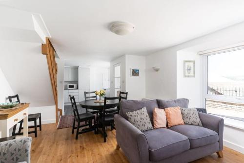 a living room with a couch and a table at Charming 3 bedroom harbour cottage with parking in Penzance