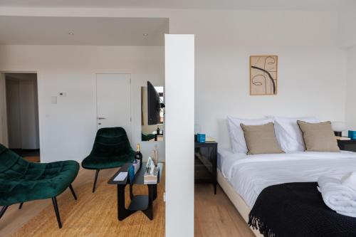 een slaapkamer met een bed en een groene stoel bij Sweet Inn - Bodeghem in Brussel