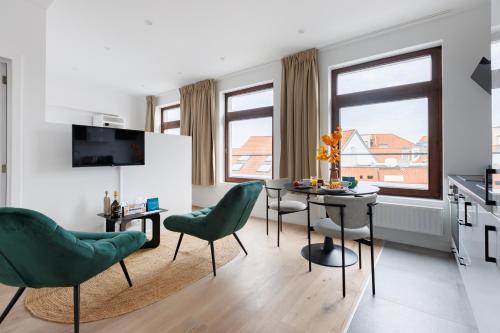 a living room with a table and chairs and a kitchen at Sweett - Bodeghem in Brussels