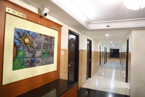 a hallway in a building with a painting on the wall at Hotel Shrie Shaanth in Salem