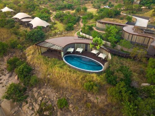 Cette chambre offre une vue sur une maison dotée d'une piscine. dans l'établissement Madwaleni River Lodge, à Ulundi