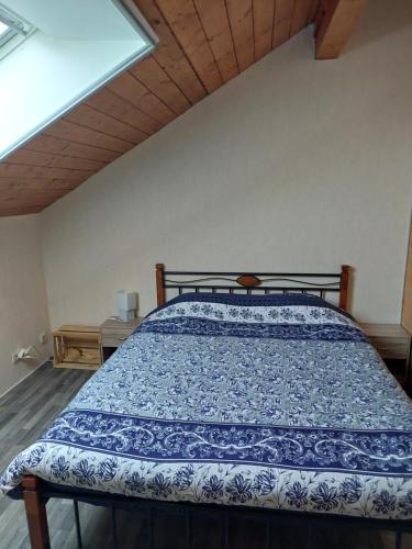 a bedroom with a bed with a blue and white comforter at Baloe in Manderfeld