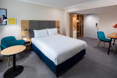 a hotel room with a bed and a table and chairs at Holiday Inn Reading South M4 Jct 11 by IHG in Reading