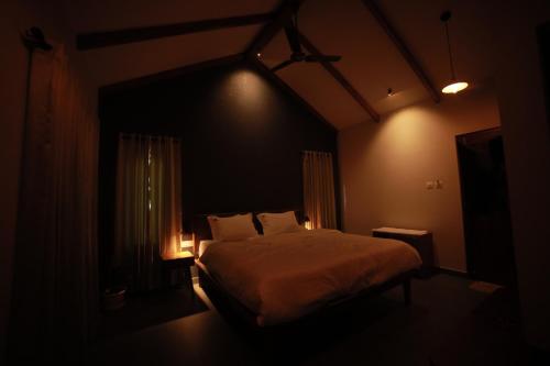 a bedroom with a bed in a dark room at SylVan Resort in Wayanad