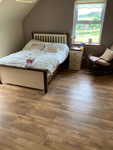 um quarto com uma cama e piso em madeira em Beautiful three bedroom, tranquil home in Ards em Letterkenny