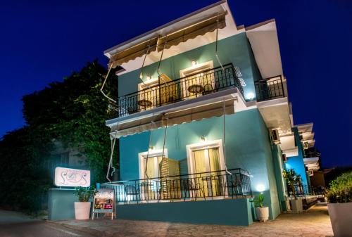 a blue building with balconies at night at Leonidas House in Parga