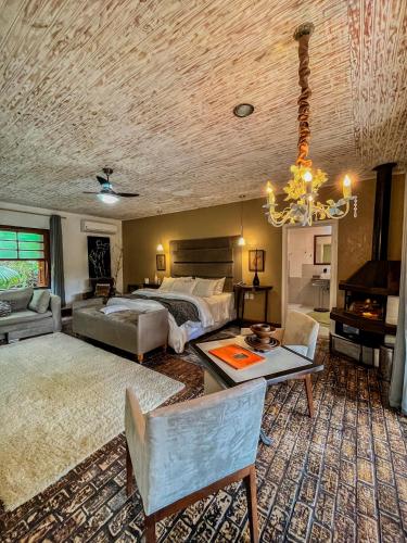 a bedroom with a bed and a couch and a chandelier at Pousada Villa 3 Lagos in Santo Antônio do Pinhal