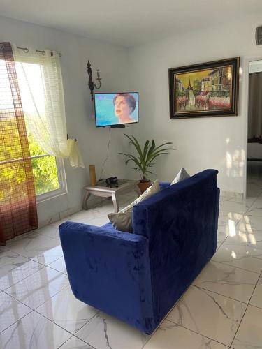 a blue couch in a living room with a tv at THOMAS BOND APARTAMENTOS in Santa Bárbara de Samaná