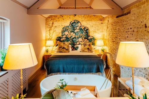 1 dormitorio con cama y bañera en The Grosvenor Stockbridge, en Stockbridge