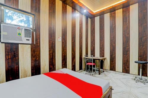 een slaapkamer met een bed, een tafel en een raam bij A5 Hotel And Dormitory in Gorakhpur