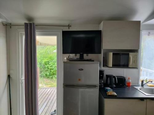 a kitchen with a television on top of a refrigerator at Lieu de paix in Camiers