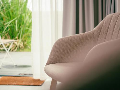 a white chair sitting in front of a window at Op Oost Boutique hotel & Restaurant het Kook Atelier in Oosterend