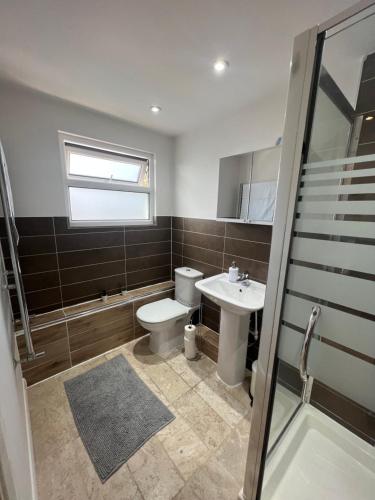 a bathroom with a toilet and a sink at Stunning House 15 min from Wembley arena in London