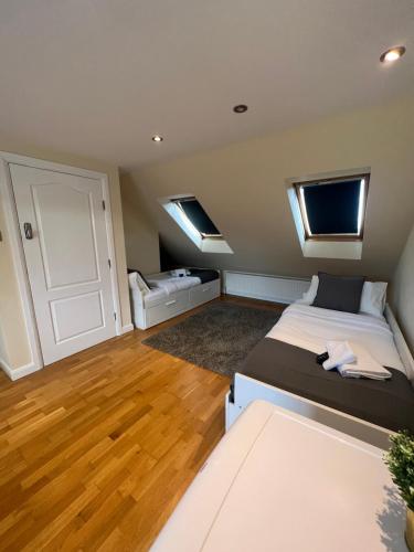 a bedroom with a large bed and two windows at Stunning House 15 min from Wembley arena in London
