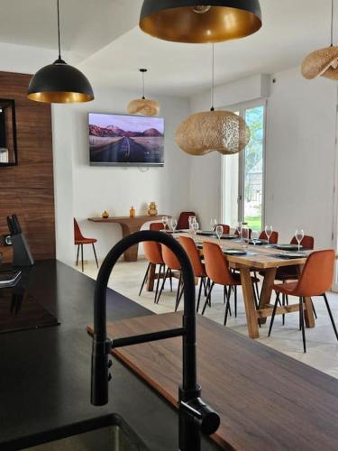 une cuisine et une salle à manger avec une table et des chaises dans l'établissement Le Petit Versailles Loire Tours, à Rochecorbon