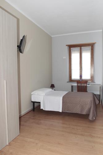 a white bedroom with a bed and a window at La Porta del Sole in Caselle Torinese